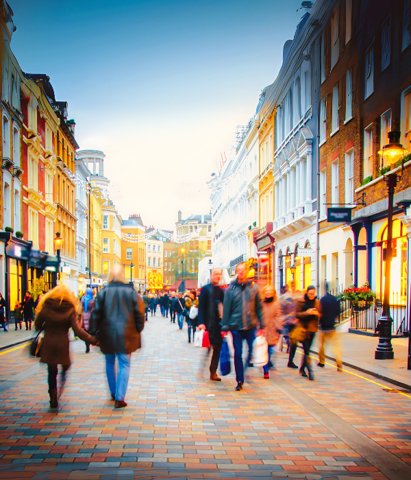 A bustling UK high street with various shops.